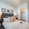 bedroom with bright bed spread, and connection to a bathroom and a large closet